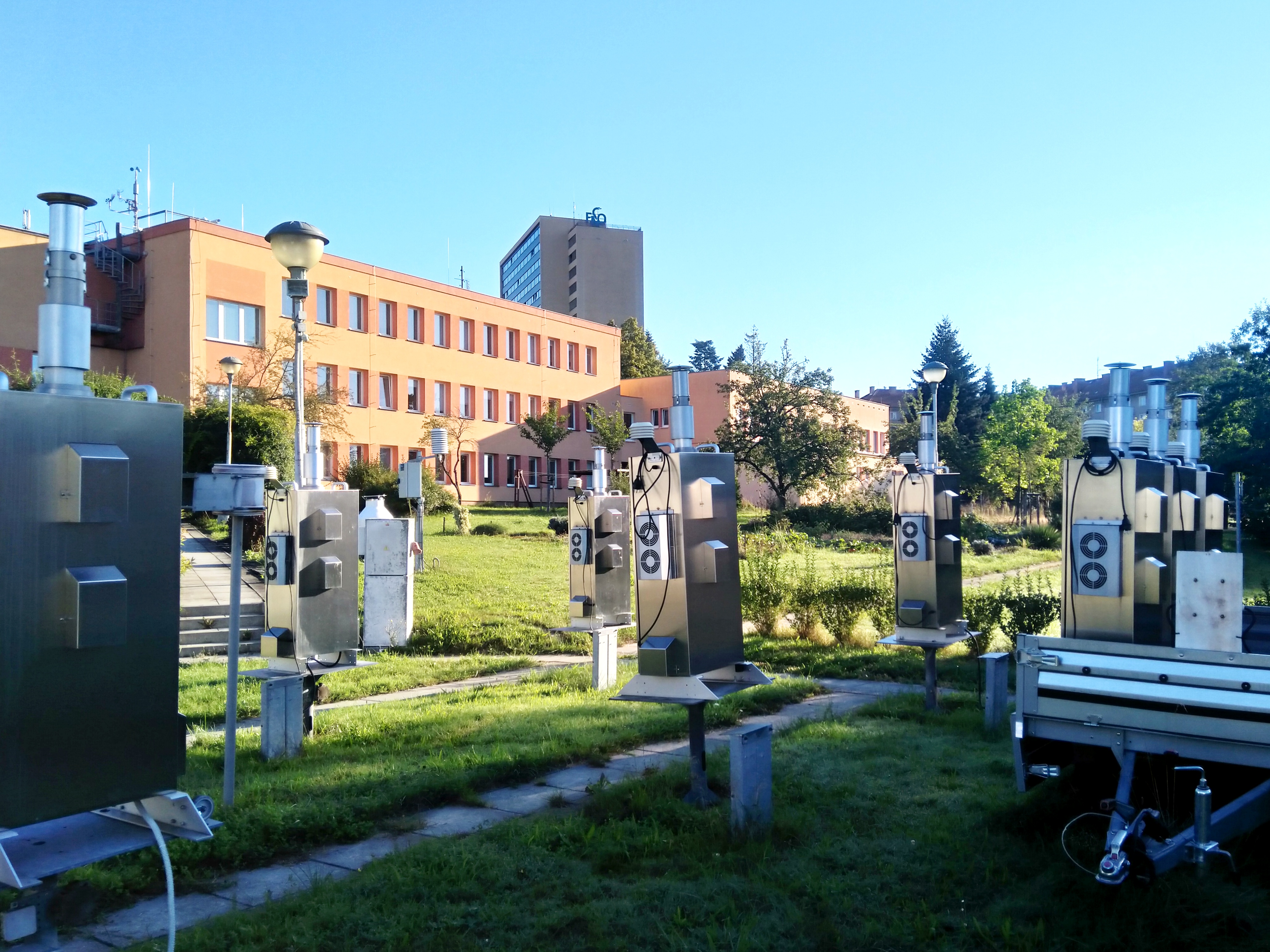 měřicí přístroje kvality ovzduší s budovou pobočky na pozadí