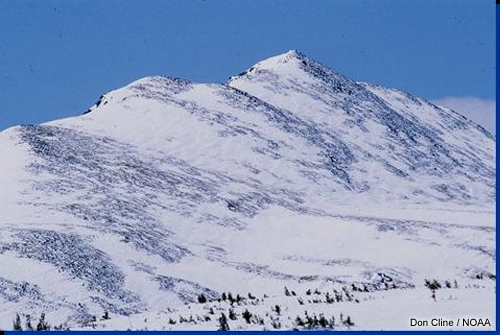Snow covering a mountainous ridge.